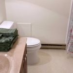 Bathroom with large vanity, toilet, mirror, and tub/shower combo