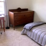 Bedroom with bed, dresser, desk, and chair