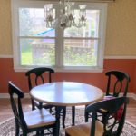 Dining room with chandelier, large window, and furniture