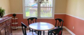 Dining room with chandelier, large window, and furniture