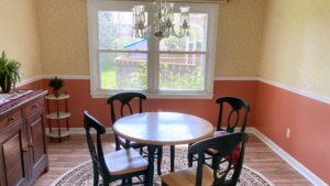 Dining room with chandelier, large window, and furniture