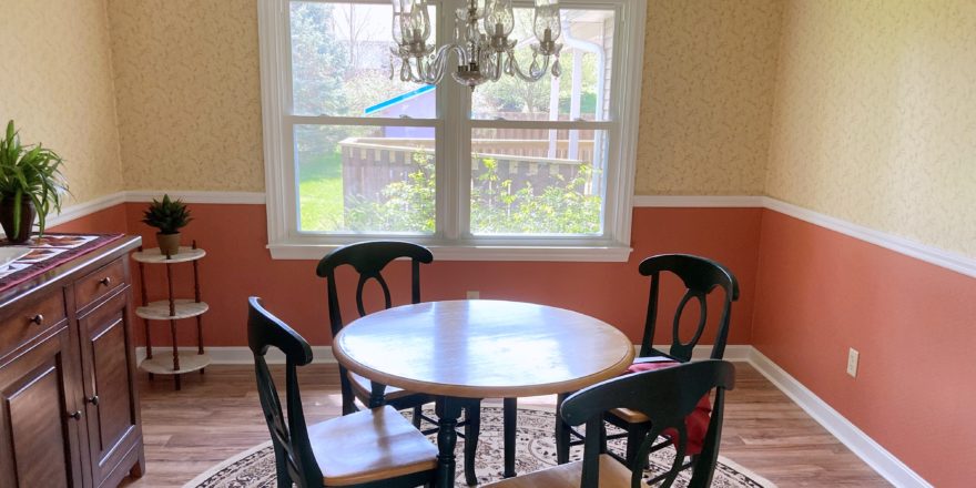 Dining room with chandelier, large window, and furniture