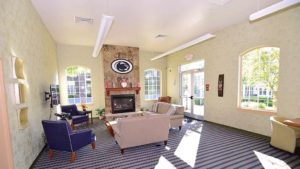 Sitting area with fireplace, large windows, and TV