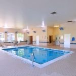 Pool area with lounge chairs and patio tables and seating