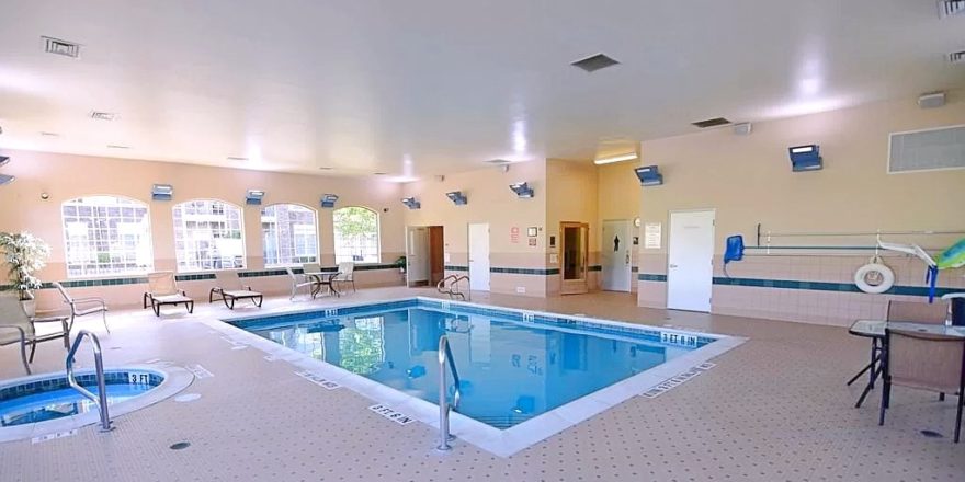 Pool area with lounge chairs and patio tables and seating