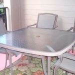 Balcony with railing, patio table and chairs, and rug