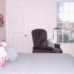 Bedroom with large bed, chair, and storage cabinet