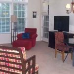 Living room with chairs, lamps, TV, and TV stand