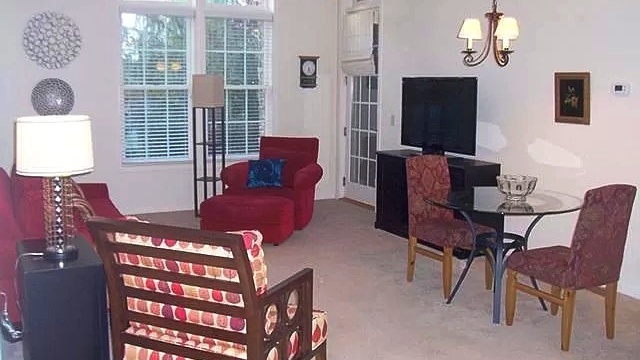 Living room with chairs, lamps, TV, and TV stand