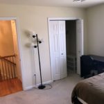 Bedroom with closet, desk with chair, lamp, and bed