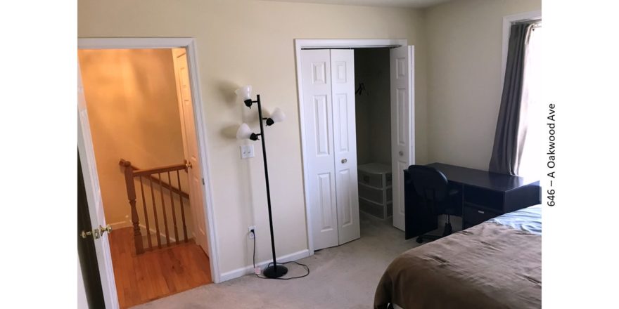 Bedroom with closet, desk with chair, lamp, and bed