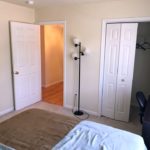 Bedroom with desk and chair, closet, and lamp