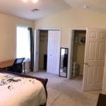 Bedroom with bed, desk with chair and two closets