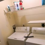 Laundry closet with side-by-side washer and dryer and shelving