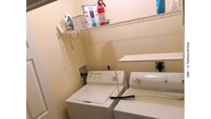 Laundry closet with side-by-side washer and dryer and shelving