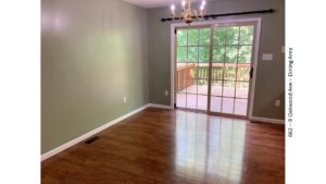 Dining area with wood-style floors and large glass slider onto a wooden deck