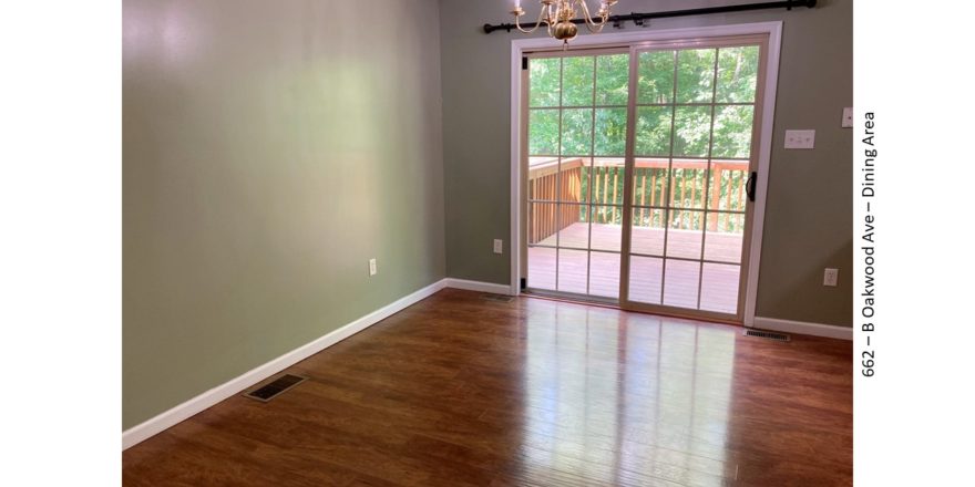 Dining area with wood-style floors and large glass slider onto a wooden deck