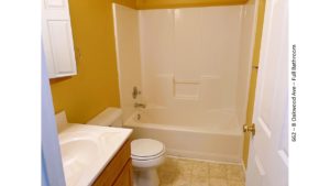 Full bathroom with medicine cabinet, vanity, toilet, and tub/shower combo