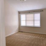 Unfurnished, carpeted bedroom with large window