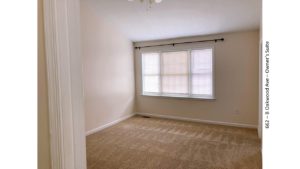 Unfurnished, carpeted bedroom with large window