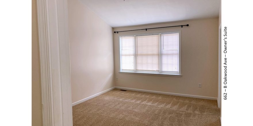 Unfurnished, carpeted bedroom with large window
