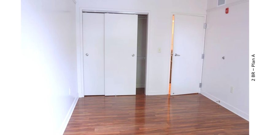 Bedroom with wood-style flooring and closet