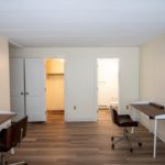Bedroom with wood-style laminate flooring and 2 desks with chairs