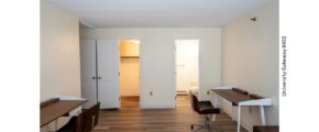 Bedroom with wood-style laminate flooring and 2 desks with chairs