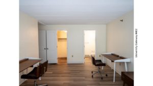 Bedroom with wood-style laminate flooring and 2 desks with chairs