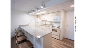 Kitchen with stone countertops, white metal cabinets, and white appliances