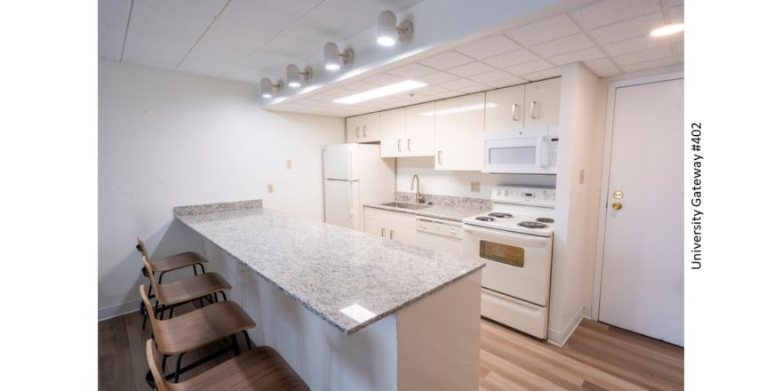 Kitchen with stone countertops, white metal cabinets, and white appliances