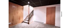 Basement area with carpet, bead board feature wall, and drop ceiling with recessed light