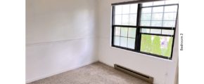 Carpeted bedroom with ceiling fan and large window