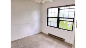Carpeted bedroom with ceiling fan and large window