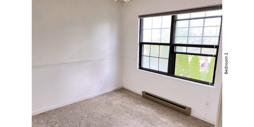 Carpeted bedroom with ceiling fan and large window