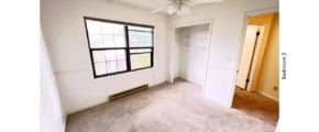 Carpeted bedroom with ceiling fan, closet, and large window