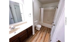 Full bathroom with large vanity, mirror, toilet, and tub/shower combo