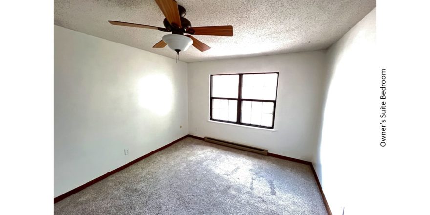 Carpeted bedroom with ceiling fan and large window