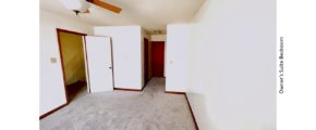 Carpeted bedroom with ceiling fan and large window