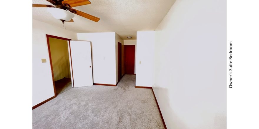 Carpeted bedroom with ceiling fan and large window