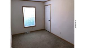 Unfurnished, carpeted bedroom with closet and a window