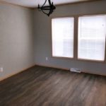 Unfurnished dining room with large windows, chandelier and LVP/LVT floor.