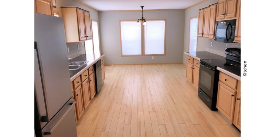 Kitchen with black and stainless steel appliances and wood-tone cabinets