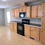 Kitchen with black and stainless steel appliances and wood-tone cabinets