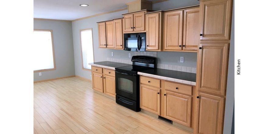 Kitchen with black and stainless steel appliances and wood-tone cabinets