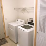Laundry room with side-by-side top load washer and front load dryer