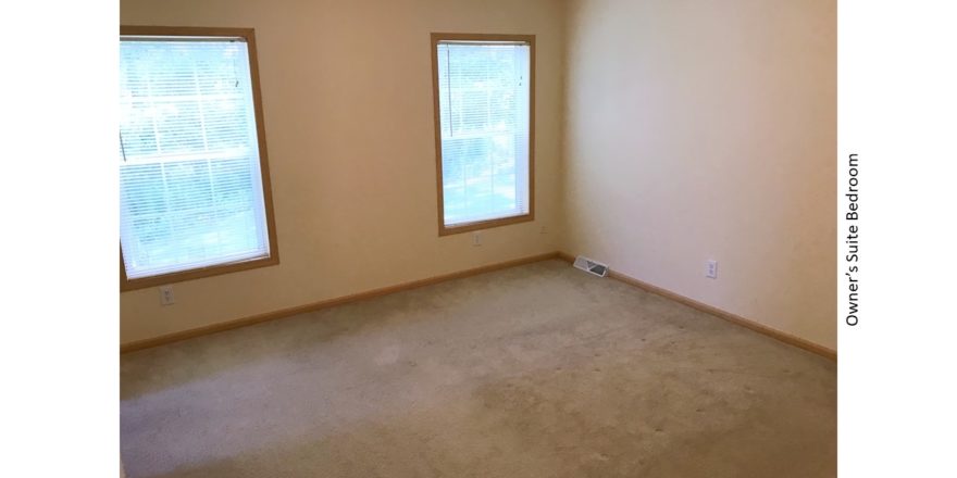 Unfurnished, carpeted bedroom with two windows