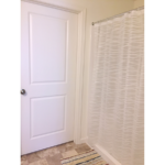 Bathroom with bath mat and shower stall