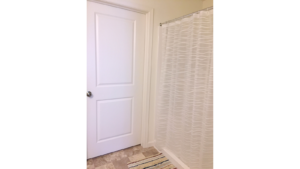 Bathroom with bath mat and shower stall