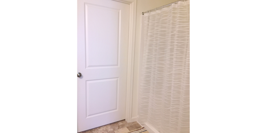 Bathroom with bath mat and shower stall